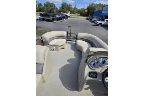 Slide: The Image of 2015 Manitou 20 Oasis Angler pontoon boat interior with beige seating and control panel. - 9