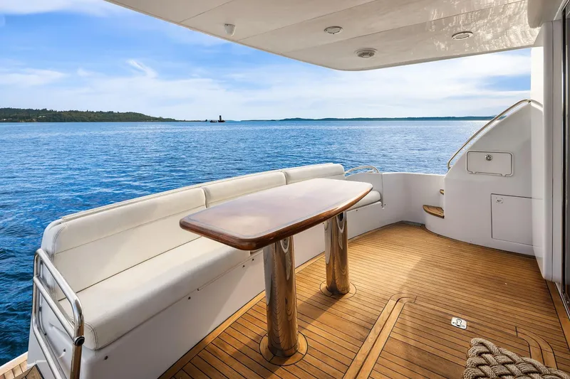 Slide: The Image of 2001 Hatteras 63 Cockpit Motor Yacht cruising on open water under blue sky. - 23