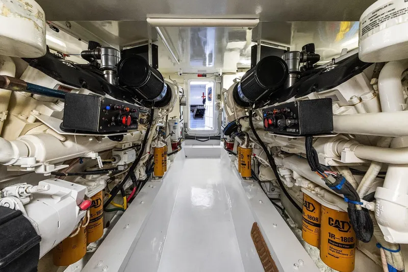 Slide: The Image of 2001 Hatteras 63 Cockpit Motor Yacht on serene blue waters under a clear sky. - 26