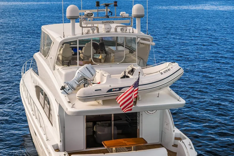Slide: The Image of 2001 Hatteras 63 Cockpit Motor Yacht cruising on open water under a blue sky. - 30