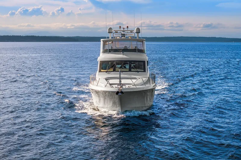 Slide: The Image of 2001 Hatteras 63 Cockpit Motor Yacht cruising on a scenic blue lake. - 31