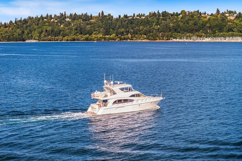 Slide: The Image of 2001 Hatteras 63 Cockpit Motor Yacht cruising on open water under a clear sky. - 32