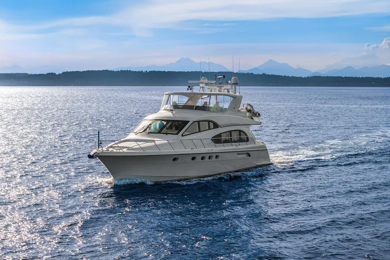 Slide: The Image of 2001 Hatteras 63 Cockpit Motor Yacht cruising on serene blue waters. - 33