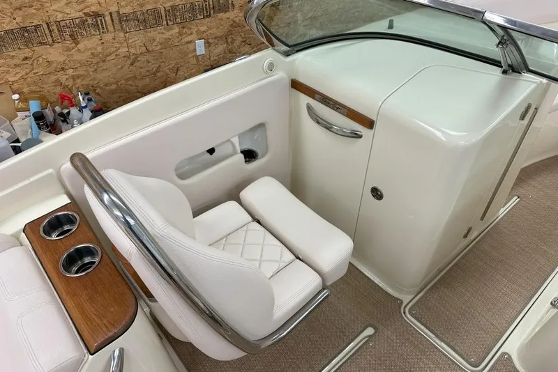 Slide: The Image of 2018 Chris-Craft Launch 27 interior with white seating, cup holders, and wood accents. - 2
