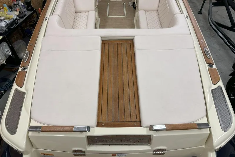 Slide: The Image of 2018 Chris-Craft Launch 27 boat interior with white seating and wooden deck. - 8