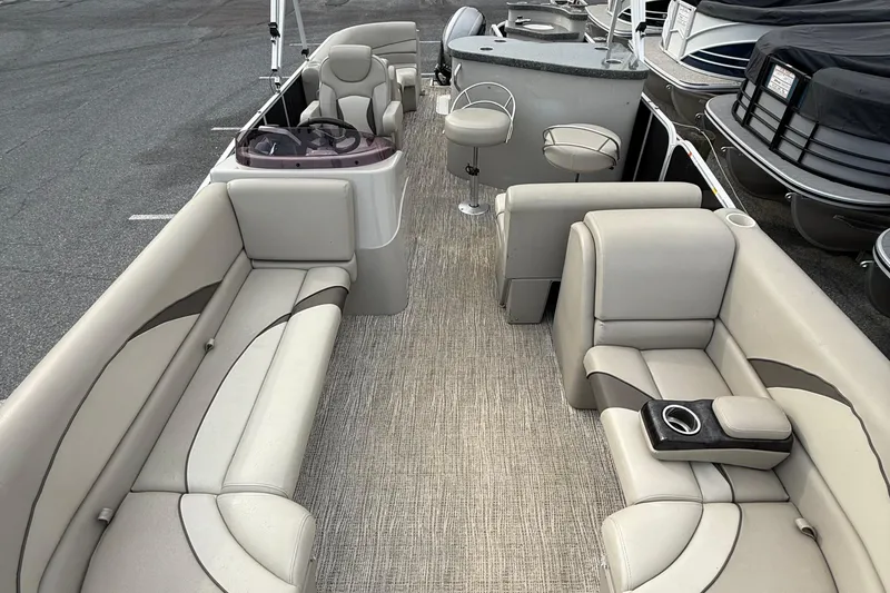 Slide: The Image of 2017 SunCatcher V22GT pontoon boat interior with beige seating and helm station. - 9