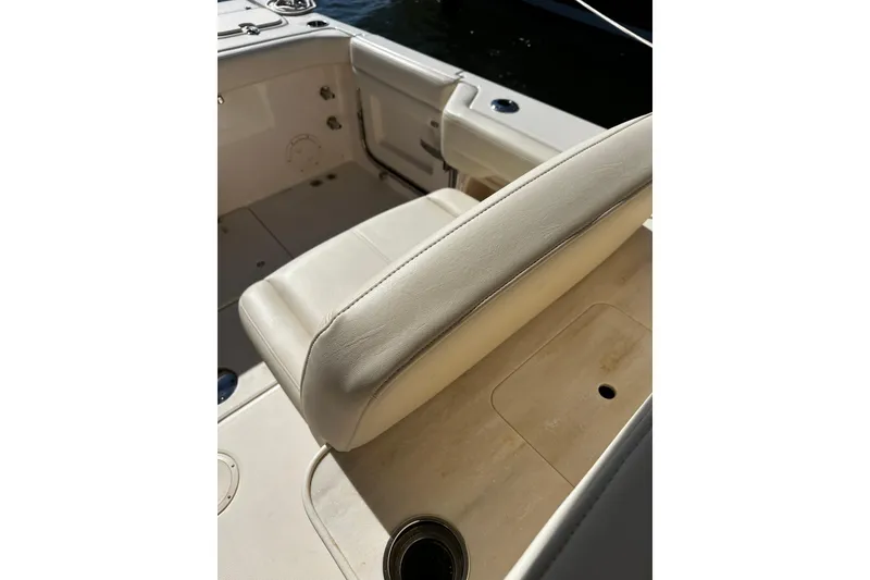 Slide: The Image of 2023 Grady-White Freedom 307 boat interior with beige seating and cup holder. - 15