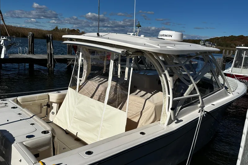 Slide: The Image of 2023 Grady-White Freedom 307 boat docked, featuring a sleek design and Garmin equipment. - 39