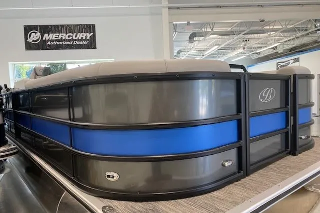 Slide: The Image of 2026 Bentley Pontoons Legacy 243 Navigator in showroom, featuring sleek design and blue accents. - 2