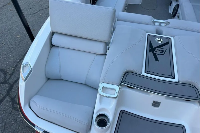 Slide: The Image of 2017 MasterCraft X23 boat interior with cushioned seating and storage compartment. - 12