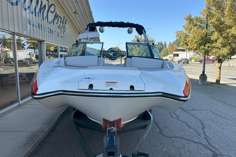 Slide: The Image of 2017 MasterCraft X23 boat on trailer outside dealership, showcasing sleek design and modern features. - 16