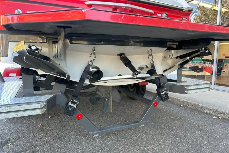 Slide: The Image of 2017 MasterCraft X23 boat on trailer, rear view showing propeller and exhaust system. - 17