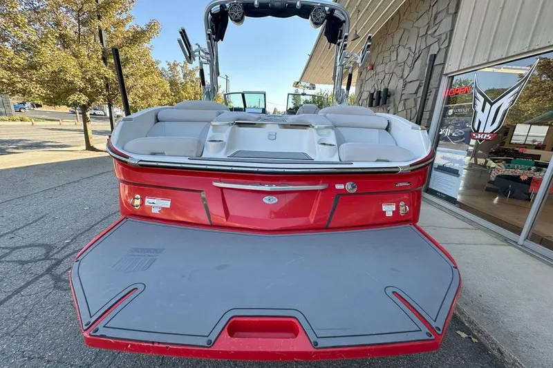 Slide: The Image of 2017 MasterCraft X23 boat, red exterior, parked outside a showroom. - 2