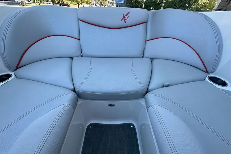 Slide: The Image of 2017 MasterCraft X23 boat interior with gray seating and red accents. - 7