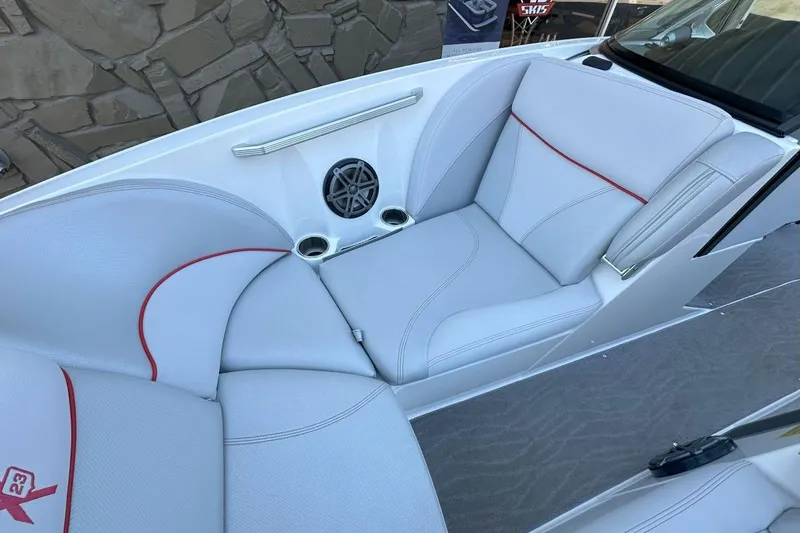 Slide: The Image of 2017 MasterCraft X23 boat interior with white seating, red accents, and built-in speaker. - 8