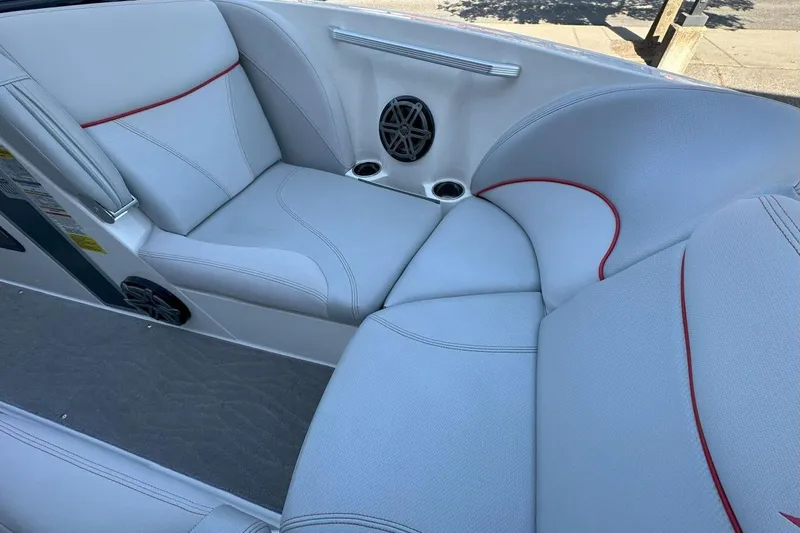 Slide: The Image of 2017 MasterCraft X23 boat interior with white seating, red accents, and built-in speakers. - 9