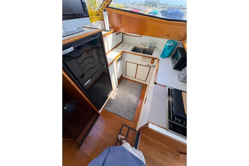 Slide: The Image of 1988 Ventare Sportfisher yacht interior kitchen with modern appliances and wooden cabinetry. - 11