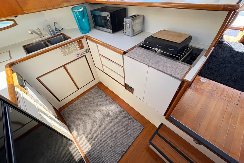 Slide: The Image of 1988 Ventare Sportfisher kitchen with modern appliances, wooden accents, and compact design. - 12
