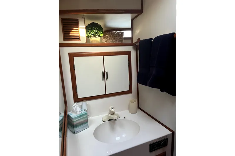 Slide: The Image of 1988 Vantare Sportfisher bathroom with sink, mirror, and towels. - 19