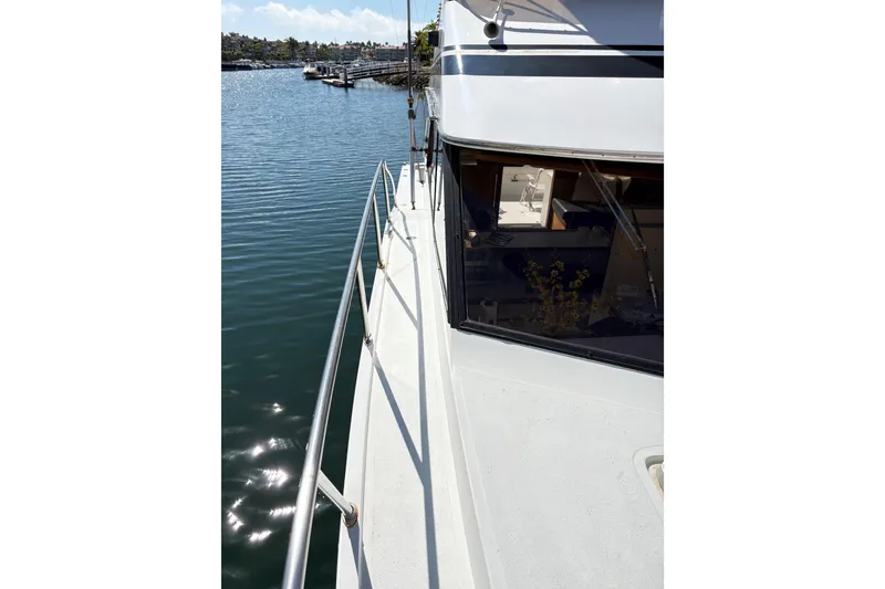 Slide: The Image of 1988 Ventare Sportfisher boat docked by calm waters, showcasing sleek design and railing. - 25