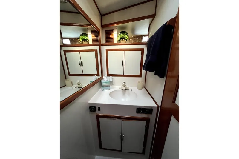 Slide: The Image of 1988 Vantare Sportfisher bathroom with sink, mirror, and wooden accents. - 37