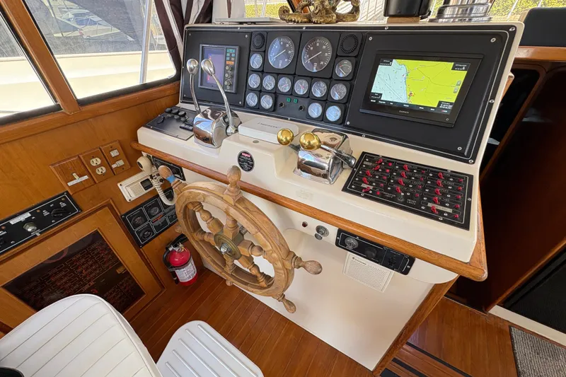 Slide: The Image of 1988 Ventare Sportfisher helm with wooden wheel, navigation controls, and electronic displays. - 9