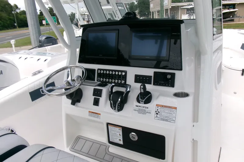 Slide: The Image of 2026 Sea Fox 288 Commander boat dashboard with steering wheel and electronic controls. - 12