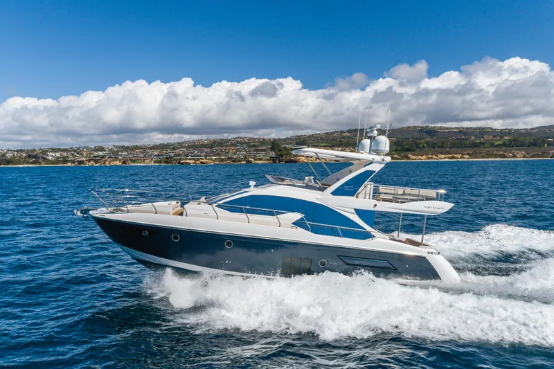 Slide: The Image of Azimut Fly 50 yacht cruising on the ocean, 2015 model, with scenic coastal backdrop. - 12
