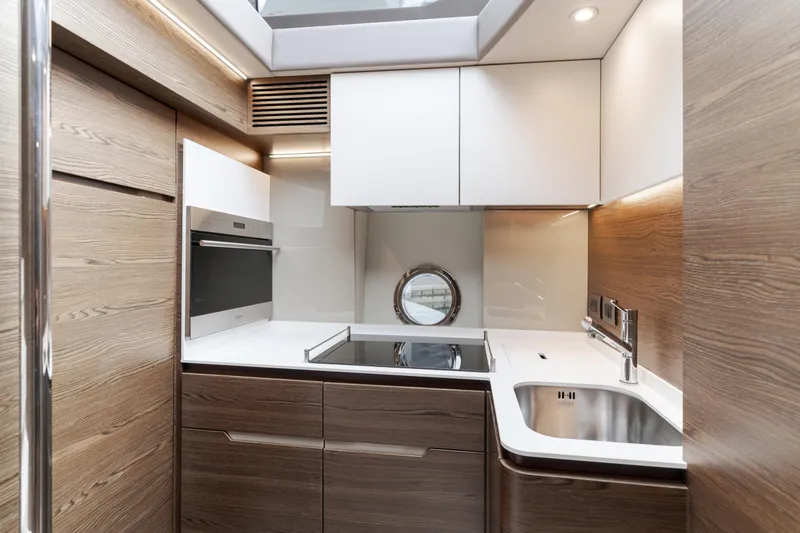 Slide: The Image of Modern kitchen interior on 2015 Azimut Fly 50 yacht, featuring sleek wood and stainless steel finishes. - 20