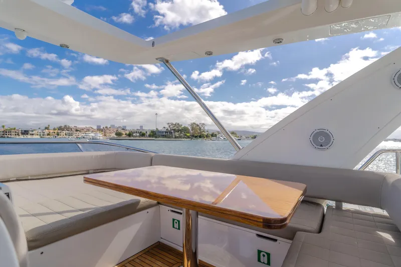 Slide: The Image of Luxurious 2015 Azimut Fly 50 yacht deck with seating and table, overlooking serene waterfront. - 38
