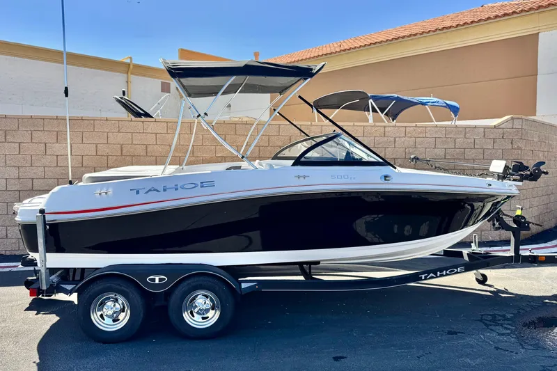 The Image of 2020 Tahoe 500 TF boat on trailer, black and white design, parked outdoors. - 0