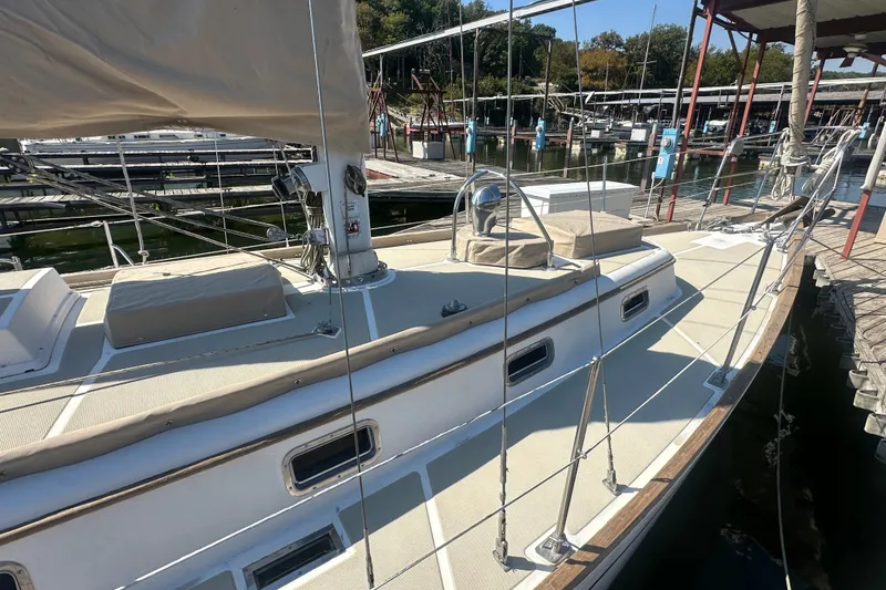 Slide: The Image of 1986 Mason 33 sailboat docked at marina, featuring sleek deck design and rigging. - 10