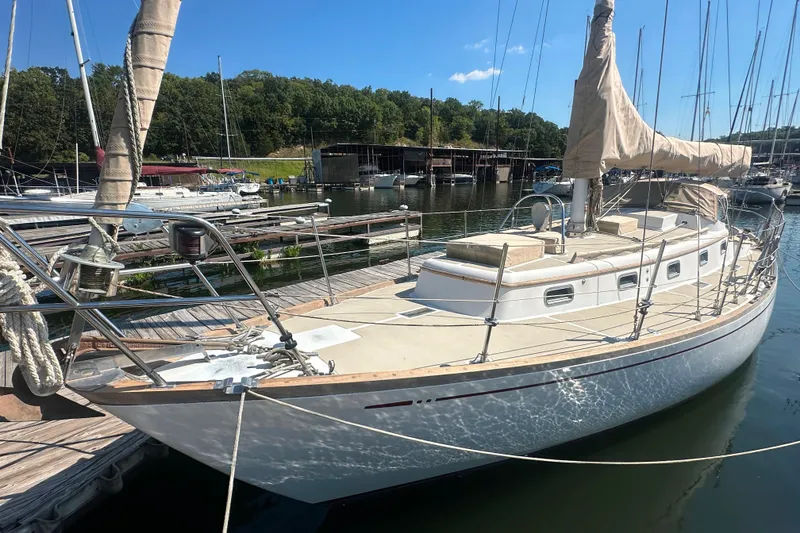 Slide: The Image of Sailboat docked at marina, Mason 33 model, 1986, with clear blue sky background. - 11