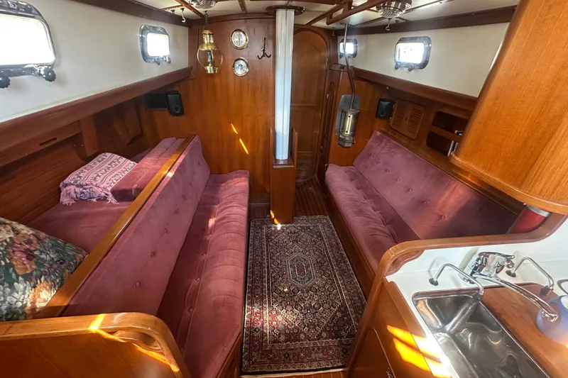Slide: The Image of Interior of a 1986 Mason 33 yacht with plush seating and wooden finishes. - 19