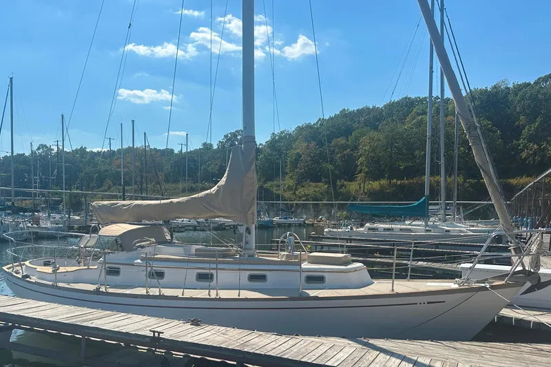 Slide: The Image of 1986 Mason 33 sailboat docked at a marina under a clear blue sky. - 2