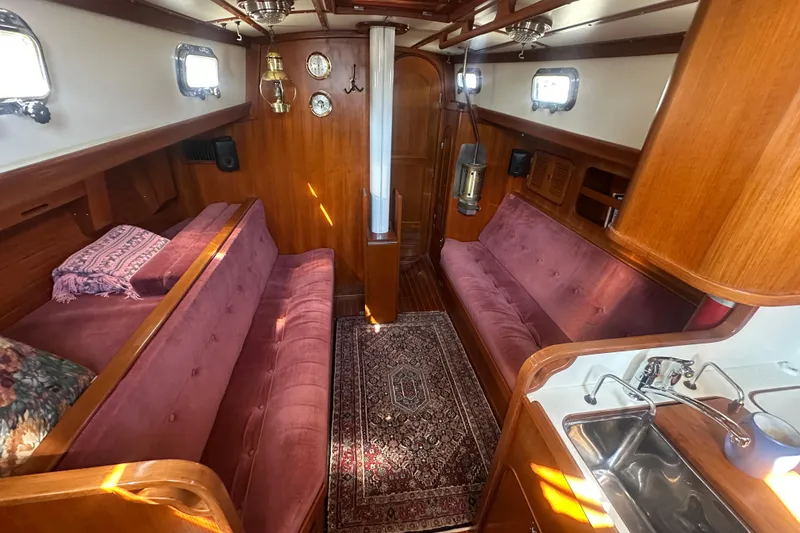 Slide: The Image of Interior of 1986 Mason 33 sailboat with plush seating and wooden finishes. - 20