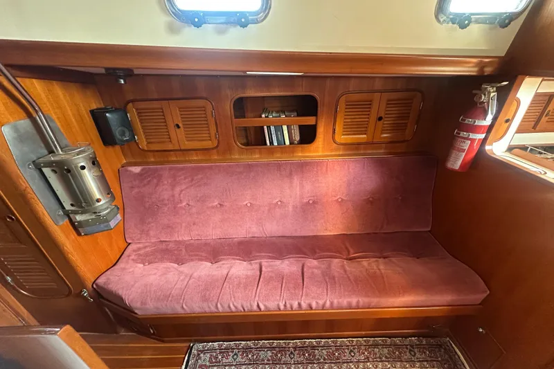 Slide: The Image of Cozy interior of 1986 Mason 33 sailboat with plush seating and wooden cabinetry. - 23