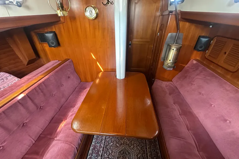 Slide: The Image of Interior of 1986 Mason 33 sailboat with wood paneling and pink cushioned seating. - 28