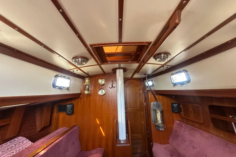 Slide: The Image of Interior of 1986 Mason 33 sailboat with wood paneling and cozy seating. - 29