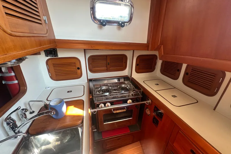 Slide: The Image of 1986 Mason 33 yacht kitchen with wooden cabinets and stainless steel sink. - 32