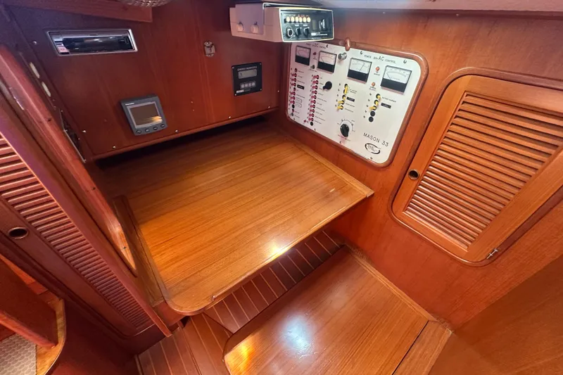 Slide: The Image of 1986 Mason 33 yacht interior with wooden paneling and control panel. - 36
