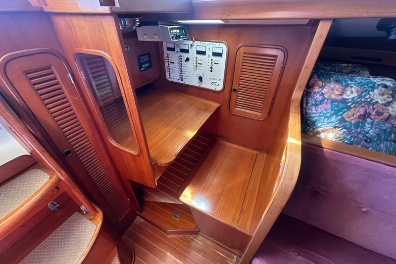 Slide: The Image of 1986 Mason 33 yacht interior with wooden cabinetry and control panel. - 39