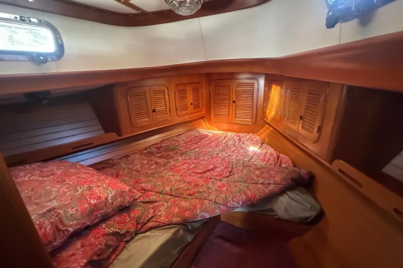 Slide: The Image of Cozy cabin interior of 1986 Mason 33 sailboat with wooden finish and patterned bedding. - 43