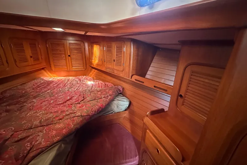Slide: The Image of Cozy wooden cabin interior of 1986 Mason 33 sailboat with bed and storage. - 44