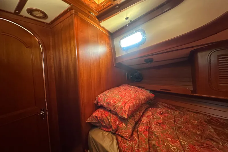 Slide: The Image of Cozy cabin interior of 1986 Mason 33 sailboat with wooden paneling and patterned bedding. - 47