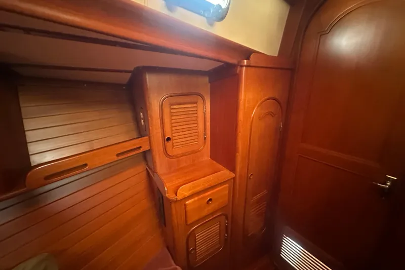 Slide: The Image of 1986 Mason 33 yacht interior with wooden cabinetry and storage compartments. - 48