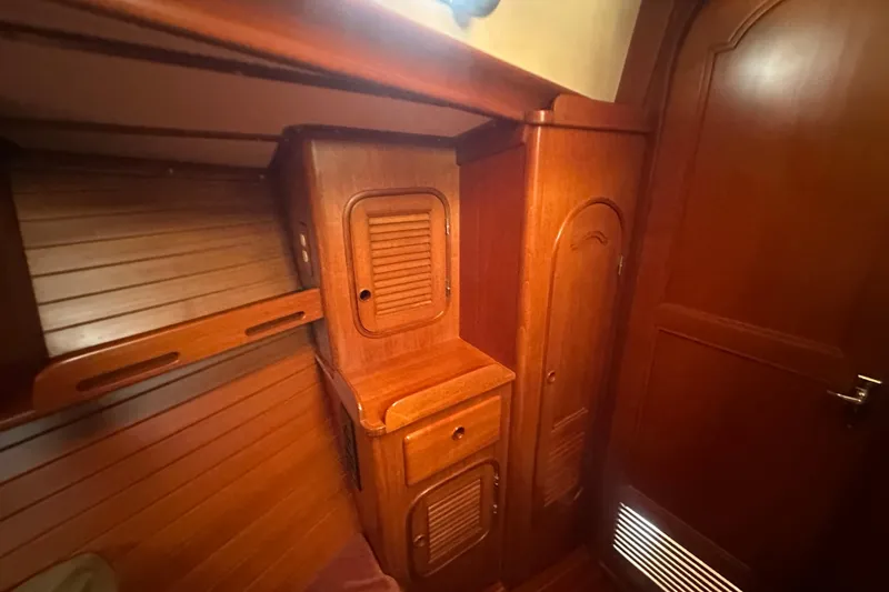 Slide: The Image of 1986 Mason 33 yacht interior with wooden cabinetry and storage compartments. - 49
