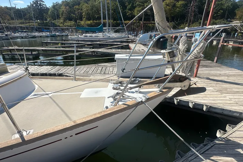 Slide: The Image of Sailboat docked at marina, Mason 33 model, 1986, with clear blue sky and trees in background. - 5