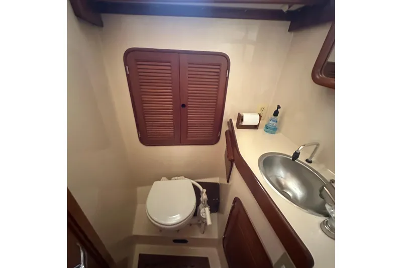 Slide: The Image of Compact bathroom in 1986 Mason 33 yacht with sink, toilet, and wooden cabinetry. - 50