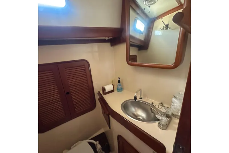 Slide: The Image of Compact bathroom in 1986 Mason 33 yacht with sink, mirror, and storage. - 51